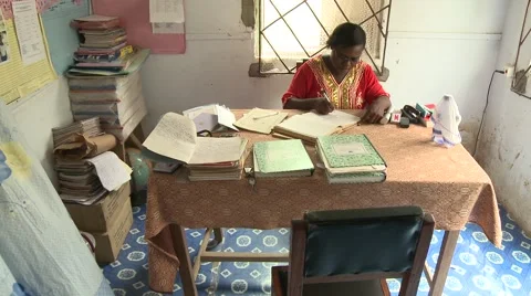 TILT DOWN FROM FAN TO HEADMISTRESS DOING PAPERWORK Stock Footage 60116105