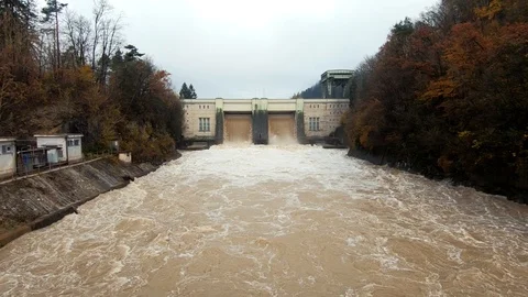 Tilt down flooded wide river brown water flowing on spillway Stock Footage 121282551