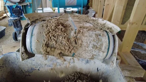 Tilt-down of fresh hempcrete falling from a conveyor belt into a box at Stock Footage 195994322