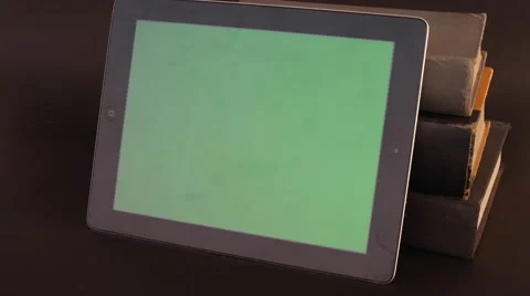 Tilt down from a green screen tablet touch screen on books Video stock 68768918