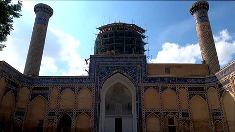 Tilt down of Gur-e-Amir Mausoleum facade to tourists in courtyard, Samarkand Stock Footage 336187975