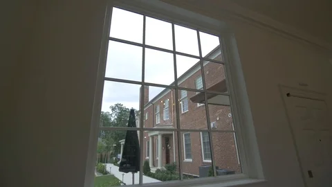 Tilt Down of Interior Window Facing Brick House Stock Footage 100899699