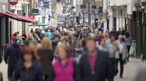 Tilt down from landmark to crowds of anonymous shoppers on British High Street Stock Footage 69071670