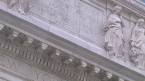 Tilt down to lion sculpture's close up in front of NY Public Library Vídeos de archivo 64990982