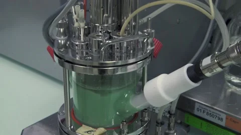 A Tilt down of machine holding green liquid in laboratory Stock Footage 155533063