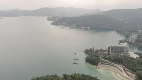 Tilt down move. Aerial drone shot of overcast Sun Moon Lake with hazy hills i 動画素材 187019551