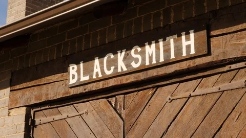 Tilt down old blacksmith sign and shop. Stock Footage 115503053