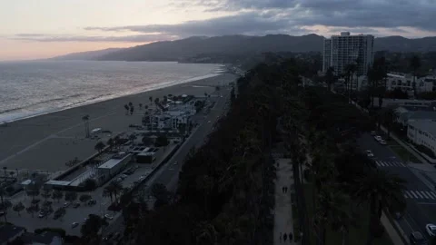 Tilt down overhead aerial of sidewalk and palms overlooking the ocean and beach Stock Footage 145033751
