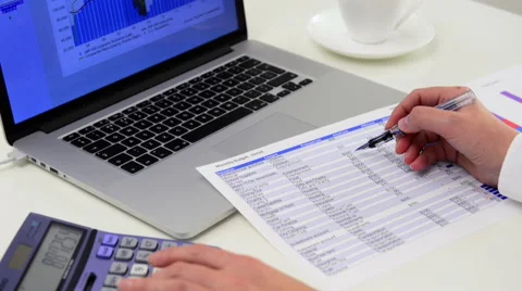 Tilt-down to person using calculator and spreadsheet Stock Footage 45892527
