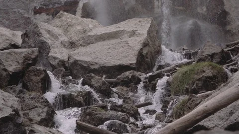 Tilt down from powerful waterfall to the crystal clear stream below Stock Footage 81419710