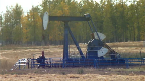 Tilt down to pump jacks working in a field for oil and gas industry. Stock Footage 59850930