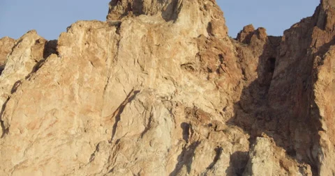 Tilt down of red rock cliff at sunrise Stock Footage 220932929