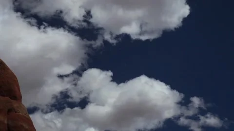 Tilt down to red rock formations, blue sky, white clouds with moving shadows Stock Footage 41750661