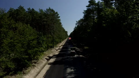 Tilt-down Shot Above A Two-Lane Road In The Middle Of The Green Fields Video stock 142007545