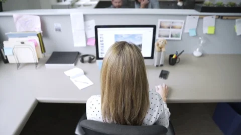 Tilt down shot of businesswoman using desktop computer while colleagues working Stock Footage