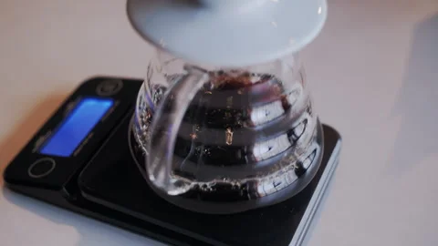 Tilt Down Shot: Coffee Drips from Syphon Filter into Vessel on Scales 스톡 동영상 307588276