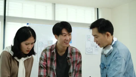 Tilt down shot of developer team collaborating and planning template layout for Stock Footage 245170443