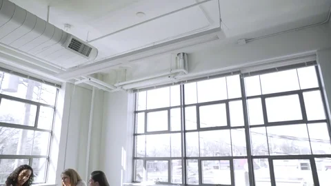 Tilt down shot of female colleagues discussing over laptop computer in board Stock Footage