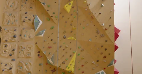 Tilt-Down shot of an Indoor Climbing Wall with Colorful Holds 库存影片 315946202