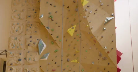 Tilt-Down shot of an Indoor Climbing Wall with Colorful Holds 库存影片 315946252