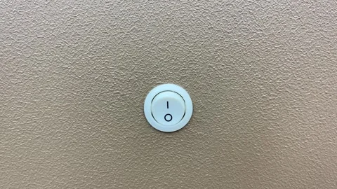 Tilt down shot light switch power on and off toggle close up view on brown wall Stock Footage 249875470
