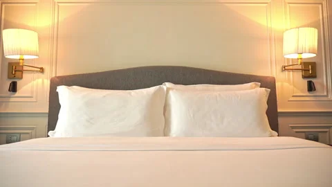 Tilt down shot of a modern freshly made resort hotel double bed with white Stock Footage 199340194