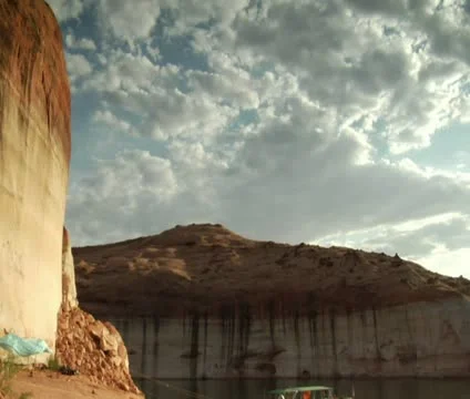 Tilt down shot from red rock cliffs to houseboat on Lake Powell Video stock 21656792