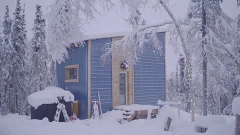 Tilt Down Shot Of Snow Covered House And Trees Near Boy By Fire During Winter - Stock Footage 254100305