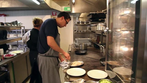 Tilt Down Shot from Steamy Ceiling to Chef Cooking in Commercial Kitchen 库存影片 343843395
