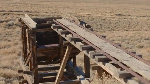 Tilt Down from Sky and Wide Open Desert to Mining Trestle and Ore Bin Stock Footage 144654532