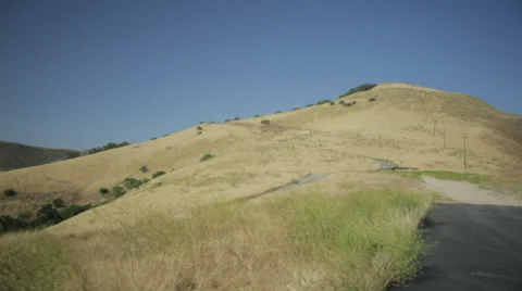 Tilt down from sky to rolling hills of grass and hay Stockbeeldmateriaal 31743930