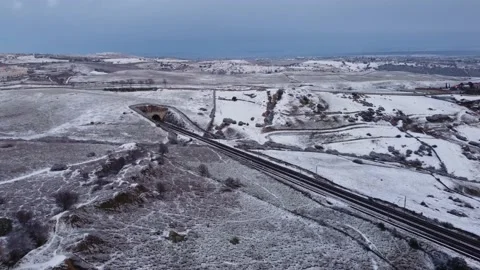 Tilt down to snow over train tracks tunnel Stock Footage 158547653