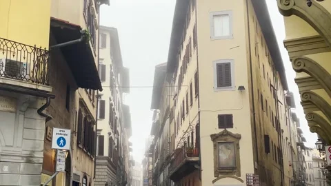 Tilt down at a street divided in Florence on a foggy day Stock Footage 264711745
