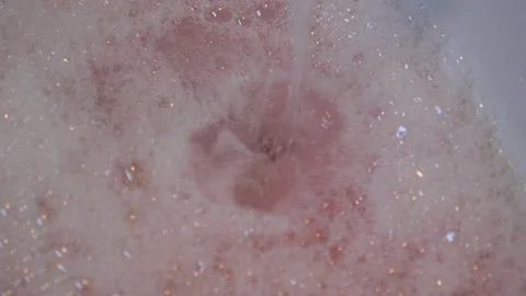 Tilt down from a tap on a bath to the plug Stock Footage 98659440