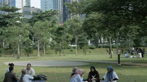 Tilt down from the top office building to the public garden in Jakarta Stock Footage 236806801