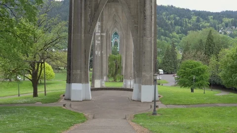 Tilt down from the underside St Johns bridge to Cathedral Park in Portland Stock Footage 92827798