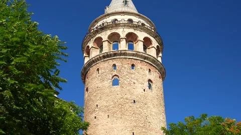 Tilt down view from below of Galata Tower with the blue sky in the background Stock Footage 250079562