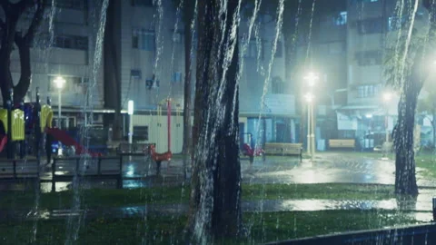 Tilt-down from Wet Pavement to Heavy Rain Pouring from Roof in Taiwan Park Stock-Footage 333082135