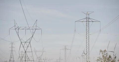 Tilt Down Wide Shot of Power Lines and Wind Mills in California Desert Stock Footage 89942504
