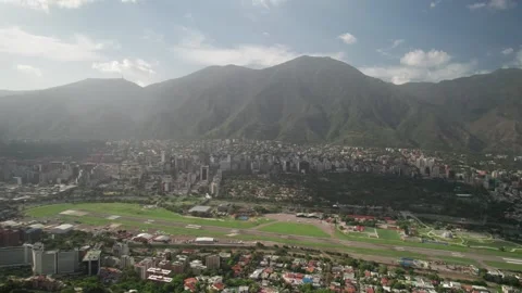 Tilt up drone from Santa Sofía revealing La Carlota cityscape in Caracas Stock Footage 316901254