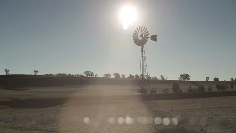 Tilt drown from a static windmill and hot sun to dry barren farmland 動画素材 127225684