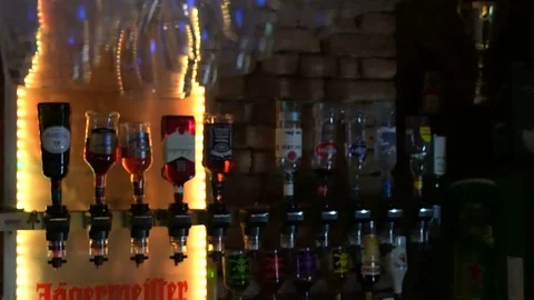 Tilt from Empty Glasses to Bottles Behind a Bar Stock Footage 87454073