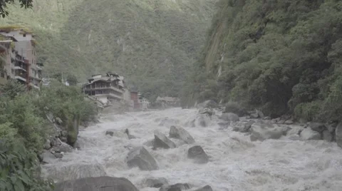Tilt of Fast Flowing River through City in the Mountains Stock-Footage 56451888