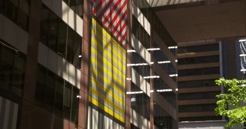 Tilt up of flags softly lit by sunlight coming through city buildings Stock Footage 67288208
