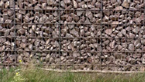 Tilt: Gabion wall next to an autobahn, motorway, rocks contained in a steel cage Stock Footage 80273572