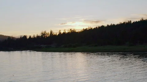 Tilt up to gorgeous pine forest lake landscape at sunset. Great establishing Stock Footage 114621966
