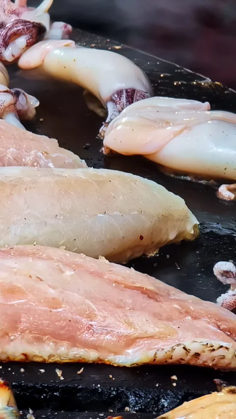 Tilt Up From Grilled Chicken to Fresh Squid on Hot Griddle Revealing Street Stock Footage 338193149