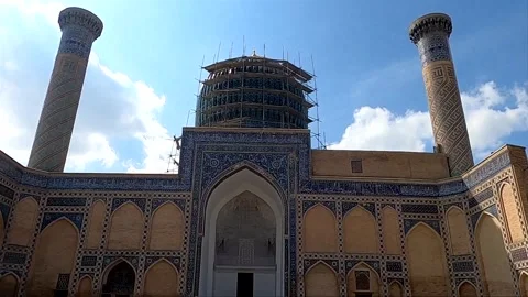 Tilt up of Gur-e-Amir Mausoleum with tourists in courtyard, Samarkand Stock Footage 336187963