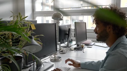 Tilt up handheld shot of creative young businessman using computer in office Stock Footage 114872274