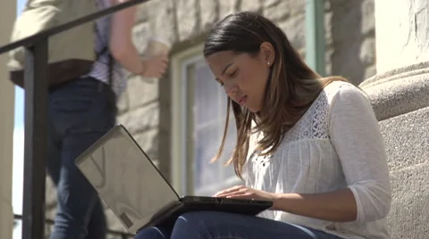 A tilt to hispanic female student using laptop on steps. Stock Footage 44117355